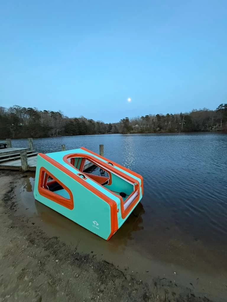 AeroCabin beside a dock at the edge of a lake at dusk.