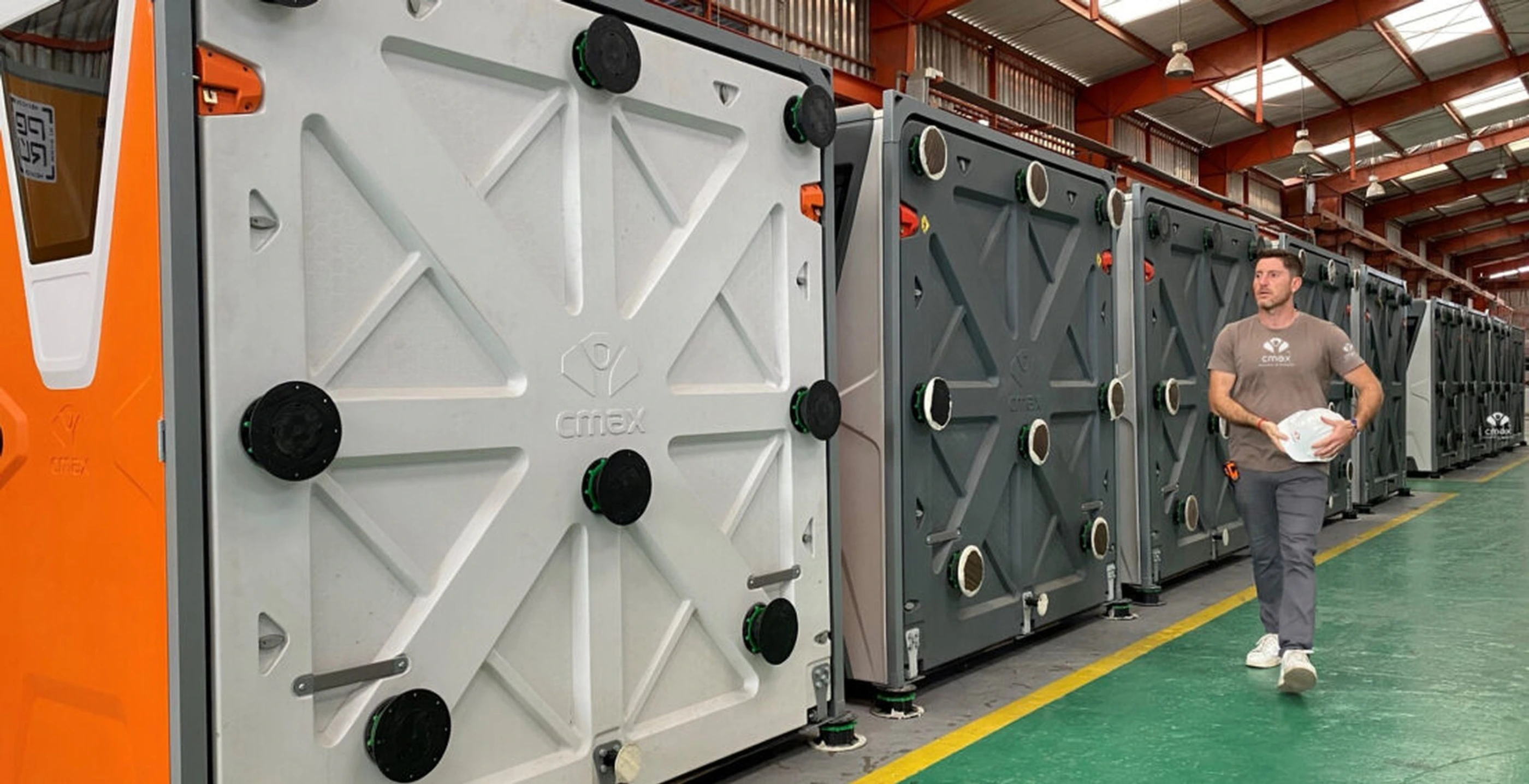 Nicolás García Mayor beside folded CMAX units inside a production facility.