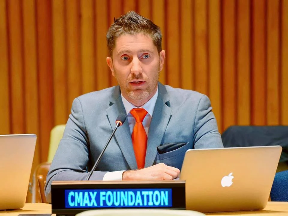Nicolás García Mayor speaking behind the CMAX Foundation nameplate.